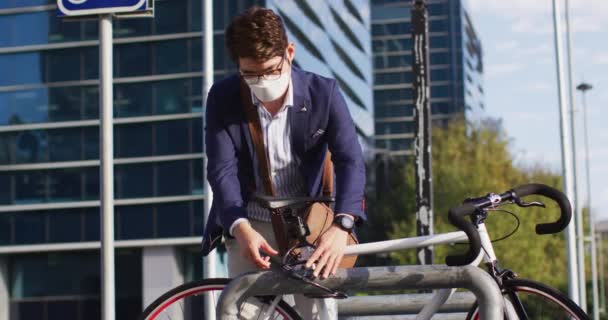 Yüz Maskesi Takan Asyalı Bir Adam Bisikletini Şirket Parkına Kilitliyor — Stok video