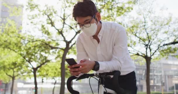 Aziatische Man Draagt Gezichtsmasker Met Behulp Van Smartphone Tijdens Het — Stockvideo