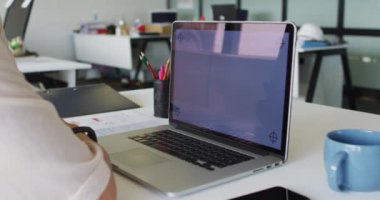 Kafkas iş kadını masada oturuyor ve ekranında kopyalama alanı olan dizüstü bilgisayar kullanıyor. Modern bir ofiste bağımsız yaratıcı iş.