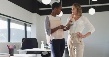 Tablete bakıp ofiste tartışan iki farklı bayan meslektaşım var. Modern bir ofiste bağımsız yaratıcı iş.