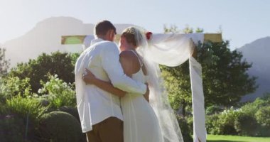 Yeni evli beyaz bir çiftin açık havada sunağın önünde dans eden portresi. romantik yaz düğünü açık havada.