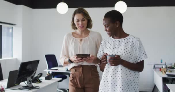 2人の多様な女性の同僚 タブレットを見て オフィスで議論を歩く 現代のオフィスで独立した創造的なビジネスを — ストック動画