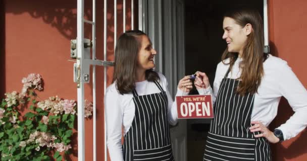 Zwei Lächelnde Kaukasische Kellnerinnen Schürzen Stehen Der Tür Und Halten — Stockvideo
