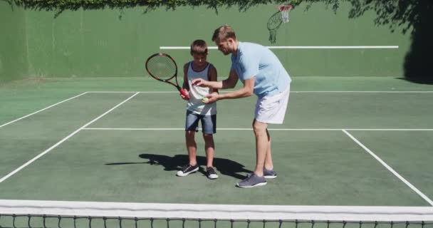 Padre Caucásico Enseñando Hijo Jugar Tenis Cancha Tenis Día Soleado — Vídeos de Stock