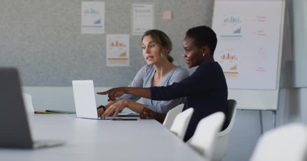 Duas Colegas Diversas Sentadas Mesa Com Laptop Discutindo Escritório Negócio — Vídeo de Stock