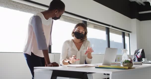 Dwie Różne Koleżanki Maskach Oglądające Laptopa Dyskutujące Biurze Niezależny Biznes — Wideo stockowe