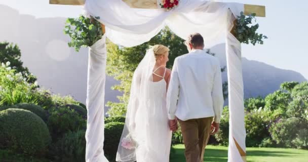 Happy Caucasian Newly Wed Couple Holding Hands Walking Altar Outdoors — Stock Video