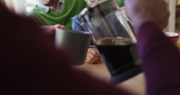 非洲裔美国人在家里和家人一起吃早餐的时候把咖啡倒在他的杯子里 爱情和融合的概念 — 图库视频影像