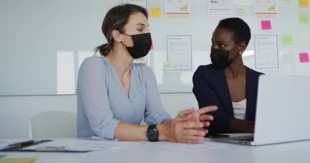 Två Olika Kvinnliga Kollegor Bär Ansiktsmask Sitter Vid Skrivbordet Tittar — Stockvideo