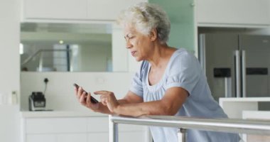 Evde akıllı telefon kullanan Afrikalı Amerikalı son sınıf öğrencisi bir kadın. emeklilik yaşlılar için karantina konsepti