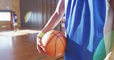 Takımla birlikte yüz maskesi takan Afrikalı Amerikalı erkek basketbolcunun portresi. Basketbol, kapalı bir sahada spor eğitimi Coronavirus covid 19 salgını sırasında.