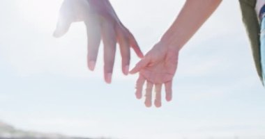 Sahilde el ele tutuşan farklı kadın eşcinsel çiftin orta kesimi. Kız arkadaşlar plajda kaynaşıyor..