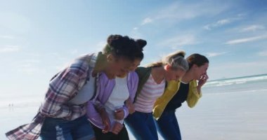 Bir grup mutlu bayan arkadaş sahilde yürürken eğleniyorlar. Tatil, özgürlük ve boş zaman.