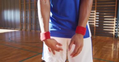 Top tutan Afrikalı Amerikalı erkek basketbolcunun portresi. Basketbol, kapalı sahada spor eğitimi..