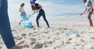 Çeşitli bayan arkadaş grupları sahildeki çöp torbalarına çöp atıyor. Çevre koruma gönüllüleri, sahil temizliği..