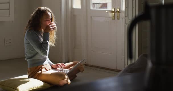 Beyaz Kadın Güneşli Salonda Dizüstü Bilgisayar Kullanarak Yerde Oturup Kahve — Stok video