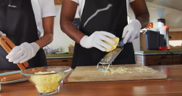 Środkowa Część Afrykańskiej Pary Fartuchach Przygotowujących Hot Dogi Ciężarówce Jedzeniem — Wideo stockowe