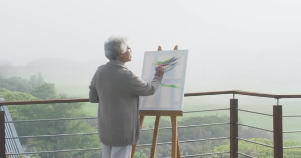 Eine Afroamerikanische Seniorin Malt Auf Leinwand Auf Dem Heimischen Balkon — Stockvideo