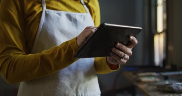 Mittelteil Einer Kaukasischen Juwelierin Der Werkstatt Mit Schürze Und Tablet — Stockvideo