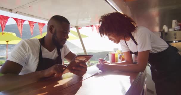 Cuplu Afro American Purtând Șorțuri Folosind Tabletă Digitală Luând Notițe — Videoclip de stoc