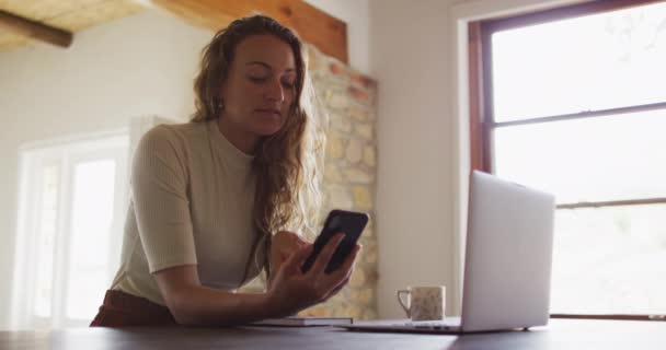 Mujer Caucásica Trabajando Desde Casa Sentada Escritorio Usando Smartphone Laptop — Vídeos de Stock