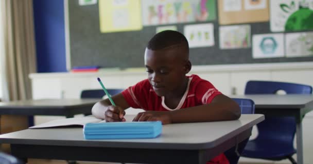 Retrato Feliz Colegial Afroamericano Sentado Aula Tomando Notas Mirando Cámara — Vídeos de Stock