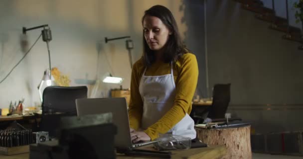 Beyaz Kadın Kuyumcu Atölyede Önlük Takıyor Masada Oturuyor Dizüstü Bilgisayar — Stok video