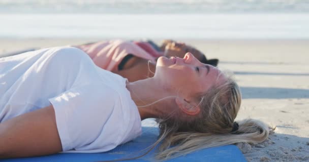 一群多样化的女性朋友在海滩上练习瑜伽 躺在垫子上 积极的生活方式 户外运动和幸福 — 图库视频影像