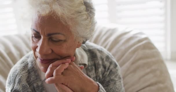 在家中坐在豆袋上的非洲裔美国老年妇女的近照下 微笑着 退休老人生活方式隔离隔离观念 — 图库视频影像