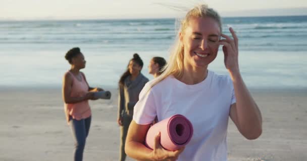 Groep Van Diverse Vrouwelijke Vrienden Die Yogamatten Het Strand Houden — Stockvideo