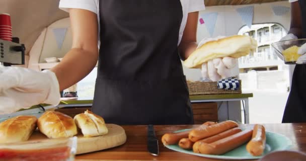 Środkowa Część Afrykańskiej Pary Fartuchach Przygotowujących Hot Dogi Ciężarówce Jedzeniem — Wideo stockowe