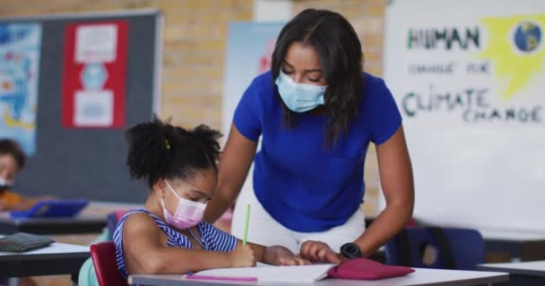 Diverse Vrouwelijke Leraar Helpen Schoolmeisje Met Les Alle Dragen Gezichtsmaskers — Stockvideo