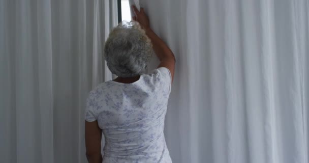 Αφροαμερικανή Ηλικιωμένη Γυναίκα Ανοίγει Κουρτίνες Του Παραθύρου Της Στο Σπίτι — Αρχείο Βίντεο
