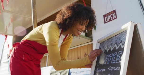 African American Woman Wearing Apron Writing Food Menu Slate Board — Stock Video