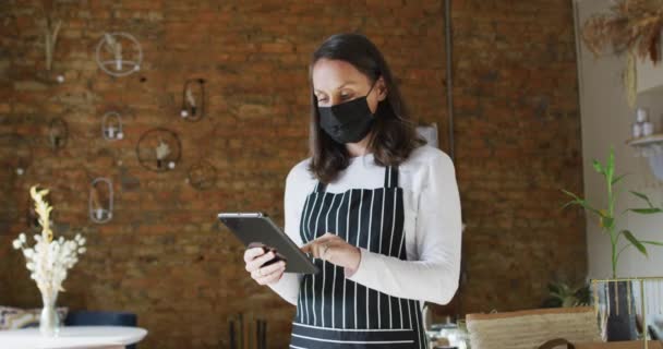 Caucasiana Empresária Vestindo Máscara Facial Avental Usando Tablet Olhando Para — Vídeo de Stock