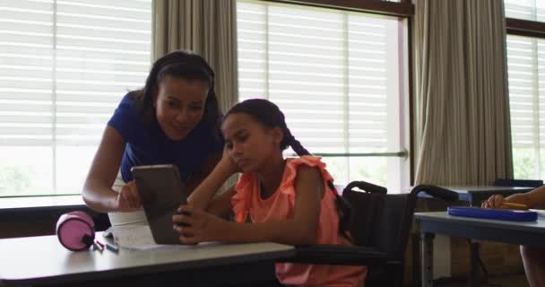 Різні Усміхнені Вчительки Допомагають Школярці Сидіти Інвалідному Кріслі Використовуючи Планшет — стокове відео