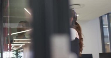 Cam duvarın yanında duran çeşitli kadın iş arkadaşları beyin fırtınası yapıyorlar. Bağımsız yaratıcı bir şirkette çalışmak.