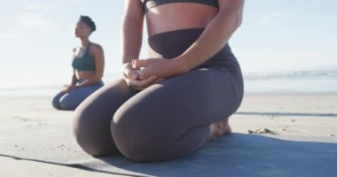 Bir grup farklı bayan arkadaş sahilde meditasyon yapıyor. sağlıklı aktif yaşam tarzı, açık hava uygunluğu ve refahı.