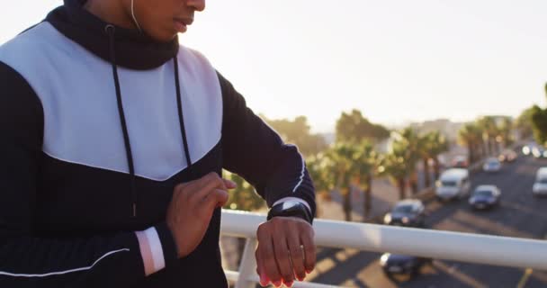 Midsection African American Man Wearing Earphones Exercising Footbridge Checking Smartwatch — Vídeo de stock