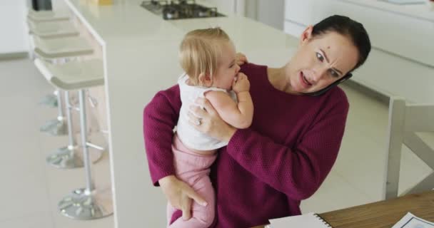 Kaukasische Mutter Hält Ihr Baby Der Hand Und Telefoniert Hause — Stockvideo