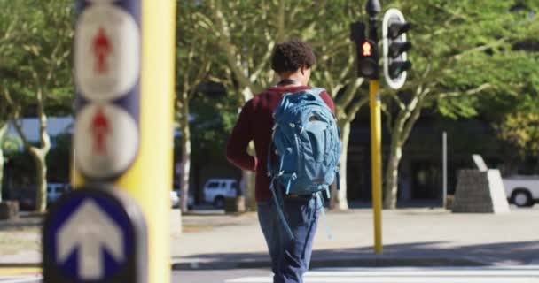 Afroamerikaner Der Stadt Der Mit Einem Rucksack Die Straße Überquert — Stockvideo