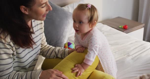 自宅のベッドでおもちゃで遊んでいる白人の母親と赤ちゃん 母親と愛と育児の概念は — ストック動画