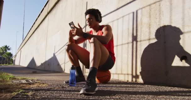 Fit African American Man City Using Smartphone Wireless Headphones Sitting — Vídeo de stock