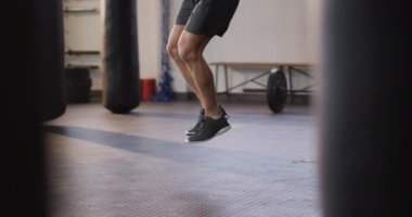 Spor salonunda atlama halatıyla çalışan beyaz bir adam. Spor, antrenman ve spor konsepti