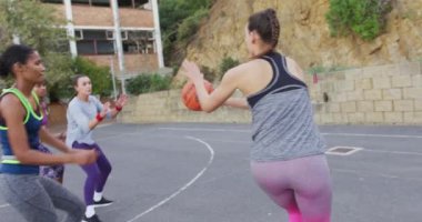Çeşitli bayan basketbol takımları maç yapıyor, top sürüyor. Basketbol, şehir merkezinde spor eğitimi..
