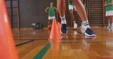 Çeşitli bayan basketbol takımlarının orta bölümü top sürme antrenmanı yapıyor. Basketbol, kapalı sahada spor eğitimi..