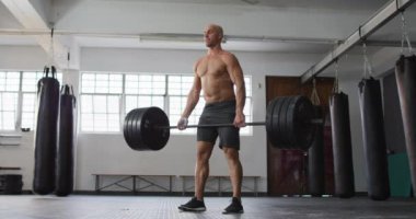 Beyaz erkek antrenör spor salonunda halterle çalışıyor. Spor. eğitim ve spor konsepti