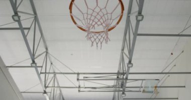 Beyaz erkek basketbolcu maç sırasında gol atıyor. Basketbol, kapalı sahada spor eğitimi..