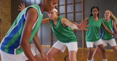 Çeşitli bayan basketbol takımları maç yapıyor, top sürüyor ve top atıyorlar. Basketbol, kapalı sahada spor eğitimi..