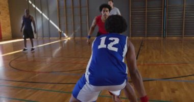 Çeşitli erkek basketbol takımları ve antrenörler maç yapıyor. Basketbol, kapalı sahada spor eğitimi..